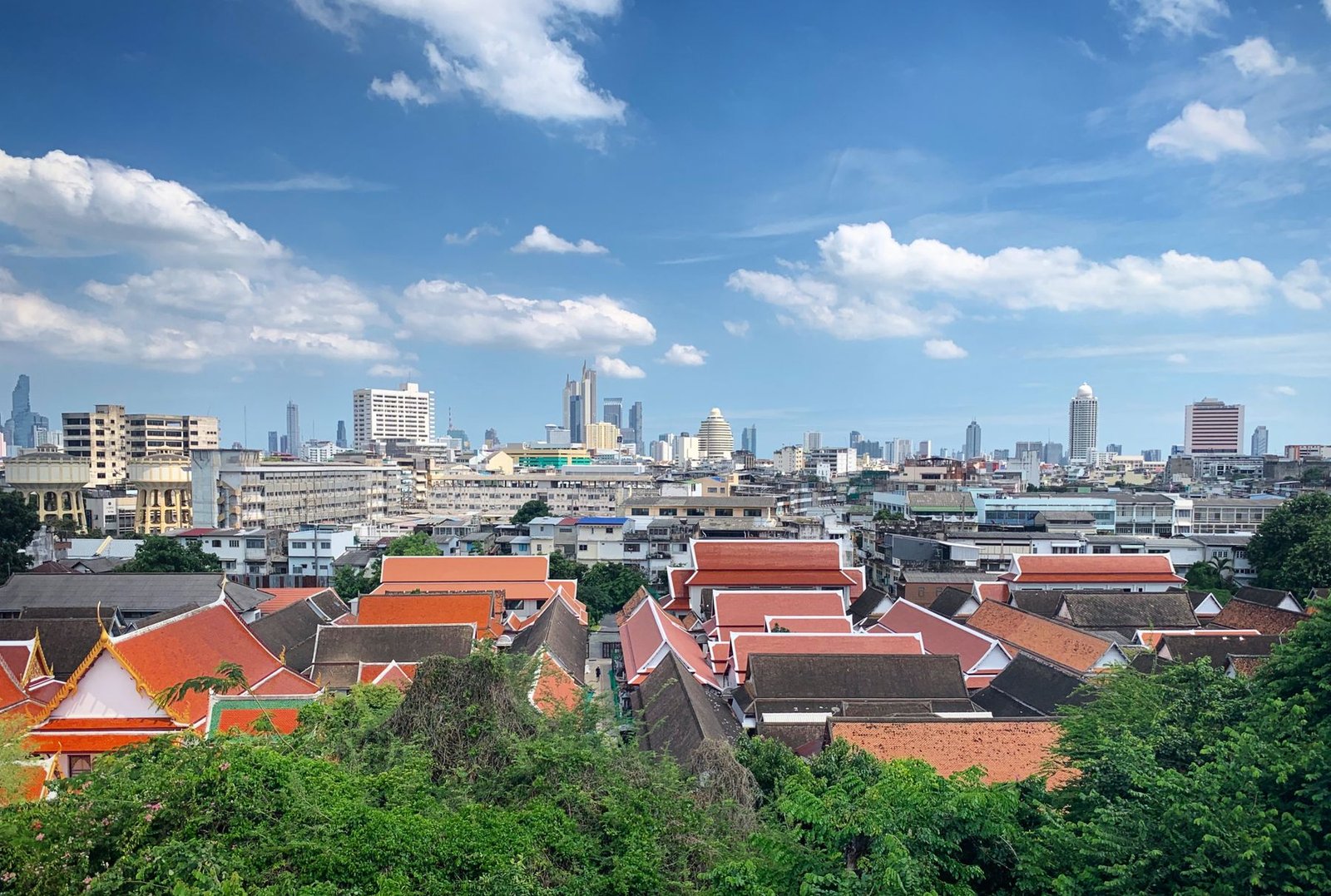 Traditional temple roofs in front of the modern Bangkok skyline